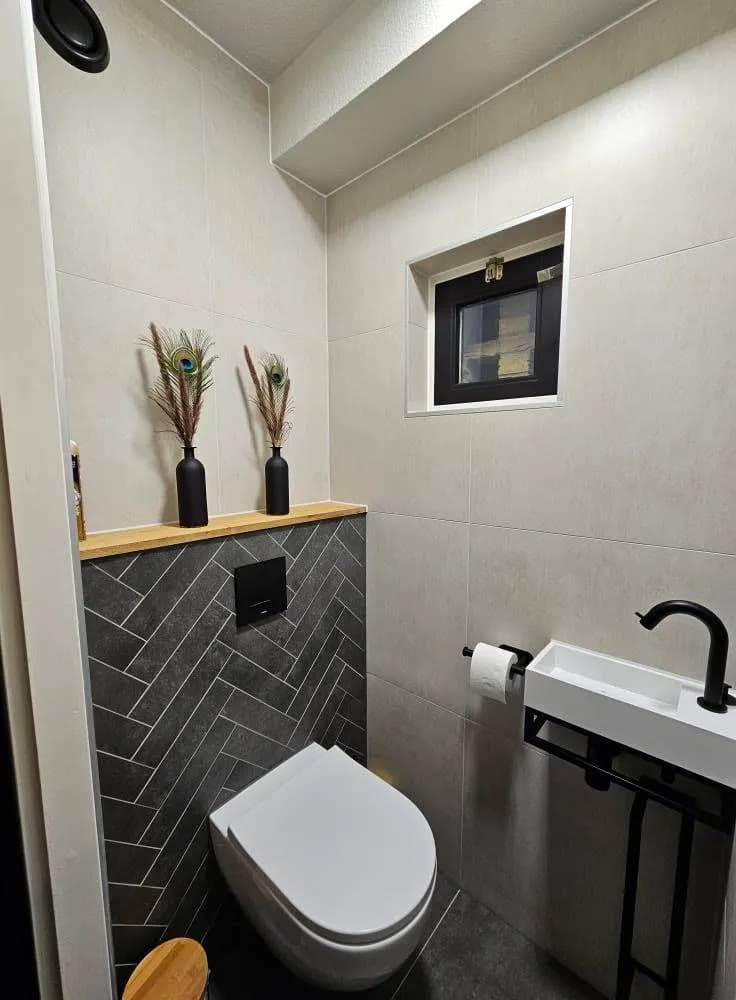 Wandtegels en vloerafwerking in gerenoveerd toilet