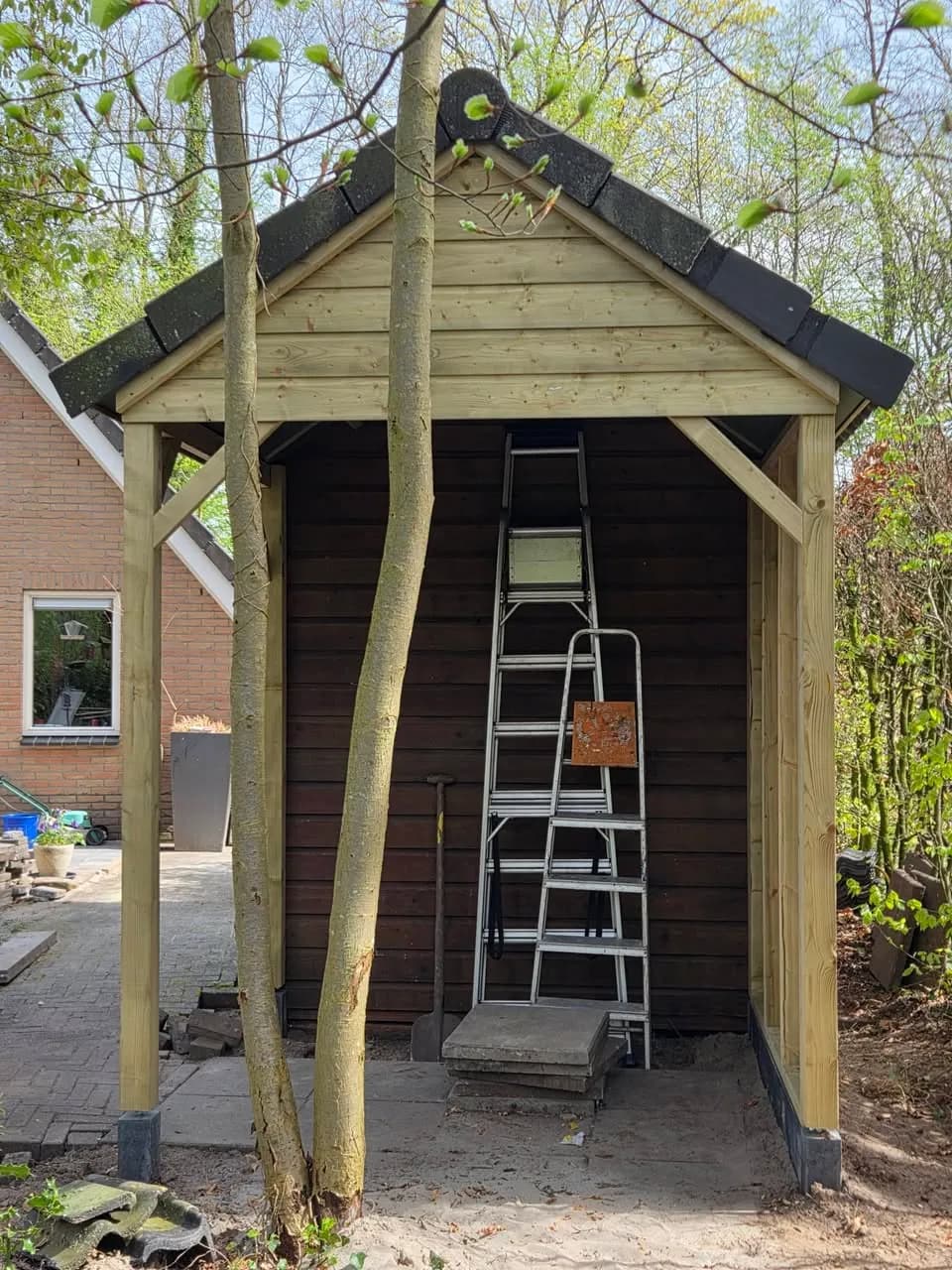 Overkapping in aanbouw naast schuurtje