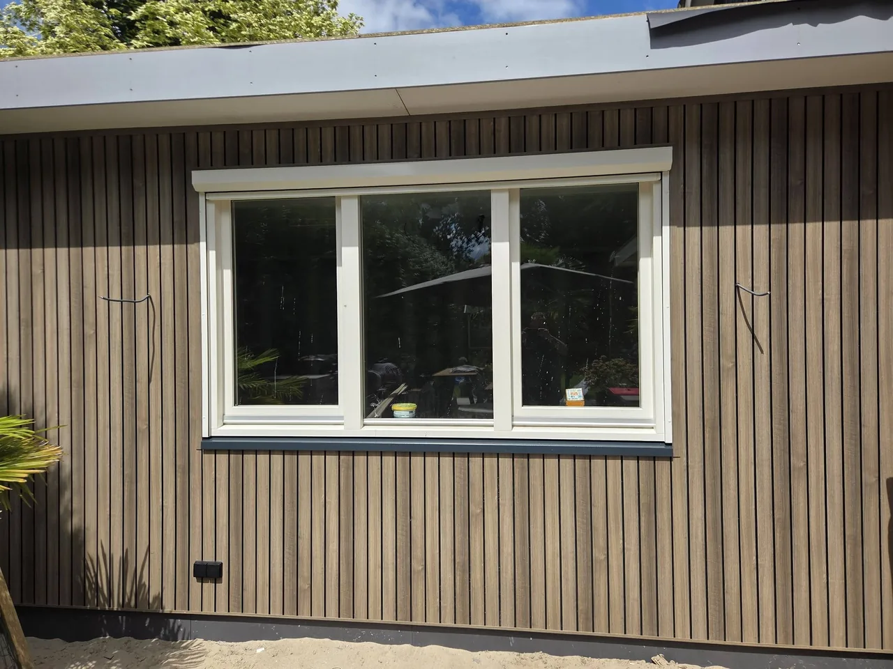 Raamkozijn in de houten gevel van de kantoor-aanbouw
