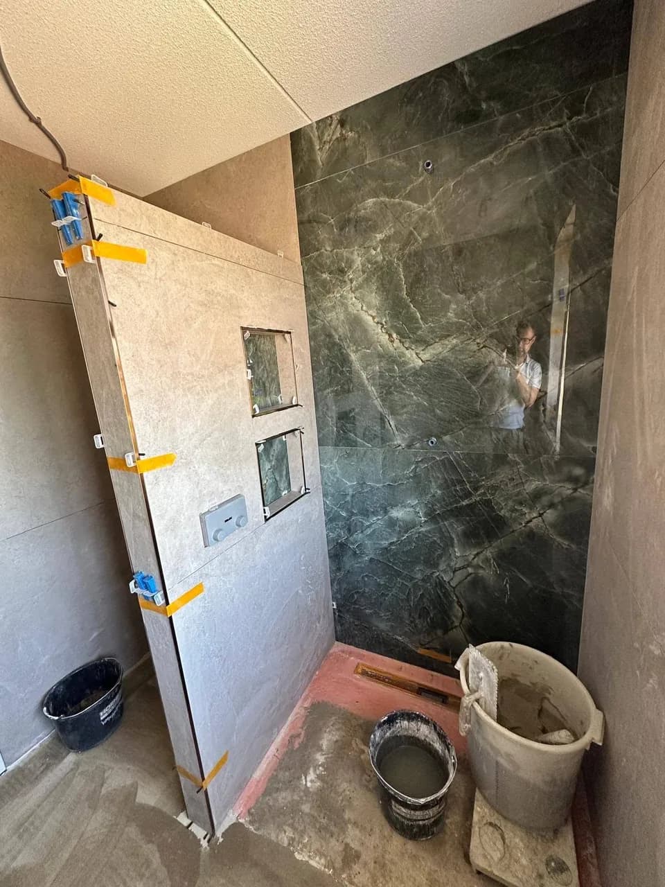 Badkamer in uitvoering met marmerlook douchewand en nisjes