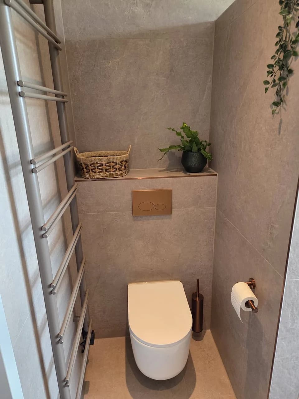 Afgewerkt toilet naast de handdoekradiator